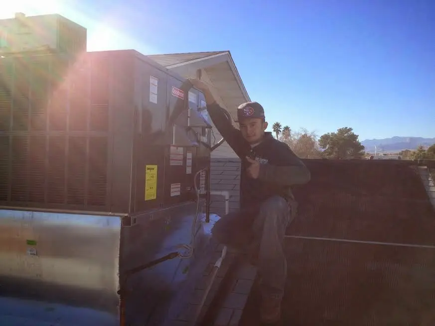 HVAC technician performing Boiler Repair on a rooftop unit in Kearns